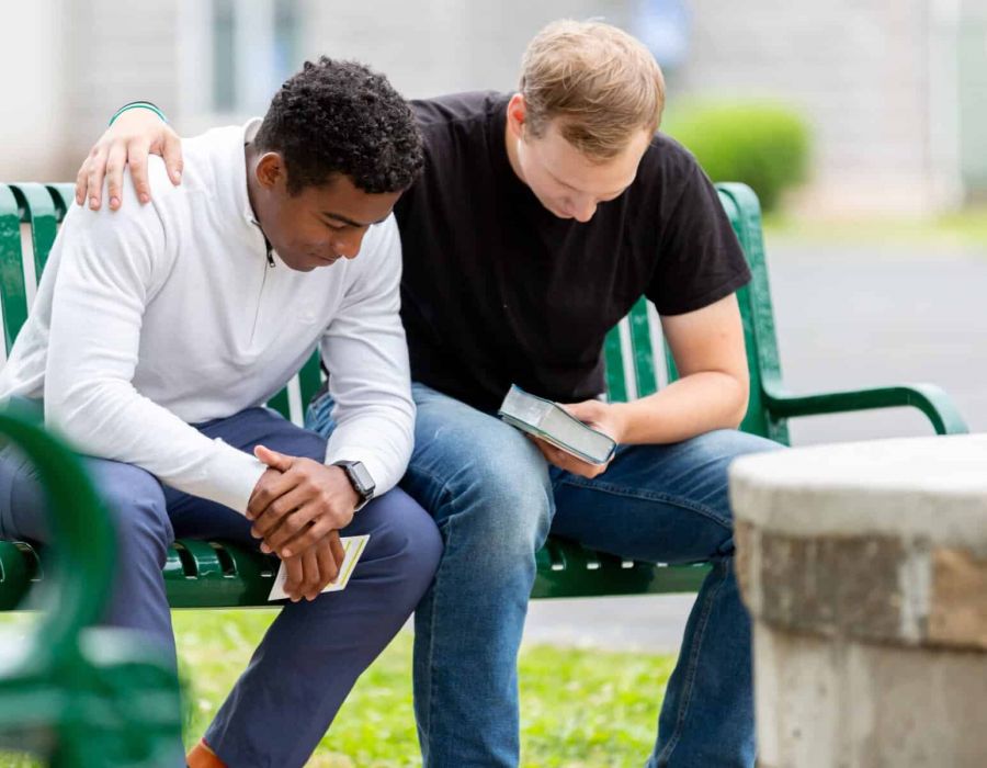 Two men reading their bibles on a bench during Nashville addiction recovery.