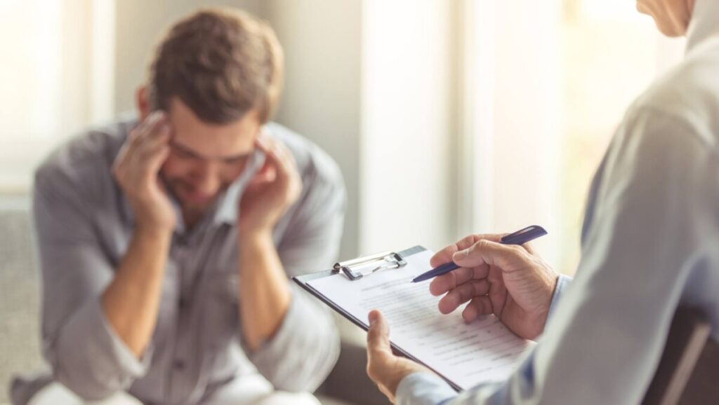 Man in therapy session addressing PTSD.