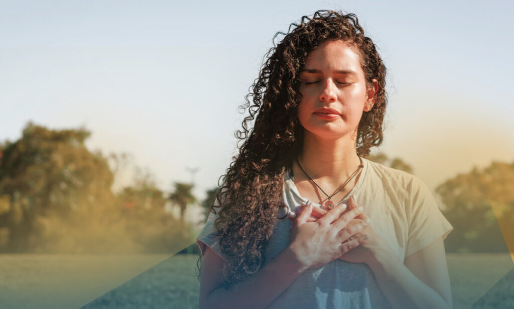 Woman with her eyes closed and hands on her chest